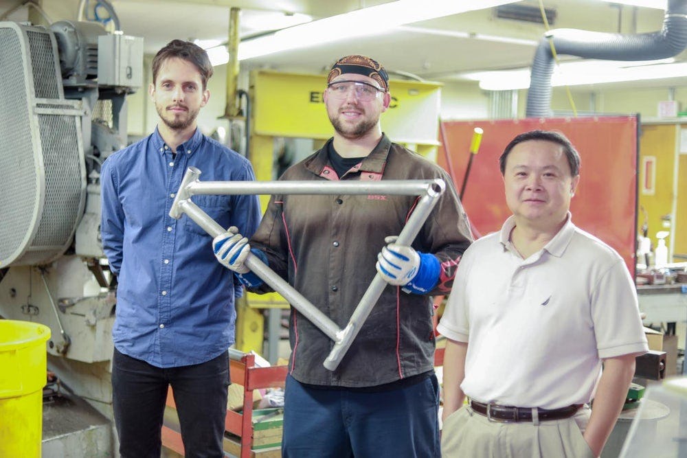 Grad student Maximilian Sokoluk (left), laboratory mechanic Travis Widick and Prof. Xiaochun Li, with a prototype welded AA7075 bicycle frame. – Photo UCLA