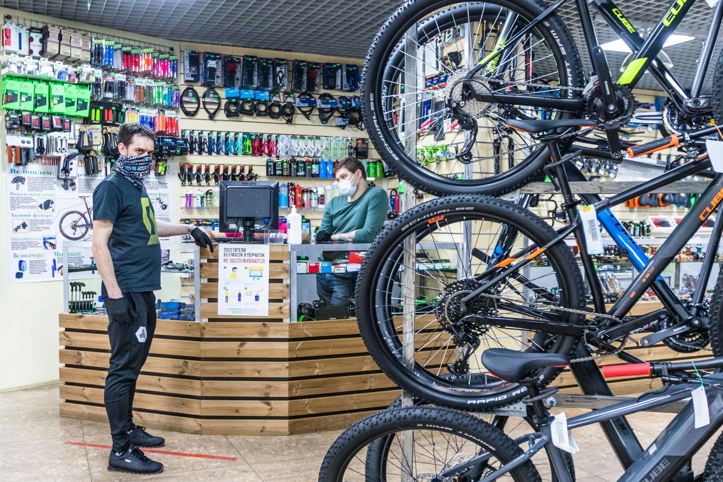A bike shop manager points at a note saying ‘Customers without mask and gloves will not be served!’ – Photo Andrey Khorkov 